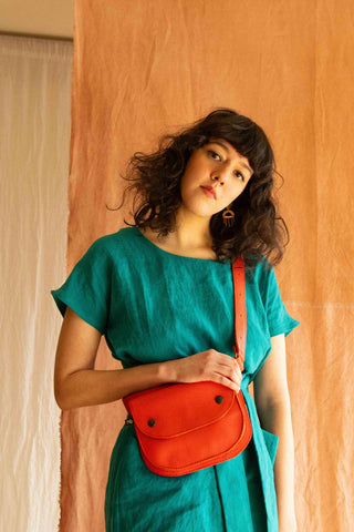 Ceinture pochette Amaru en cuir recyclé corail, fusionnant mode et fonctionnalité avec un impact écologique réduit.